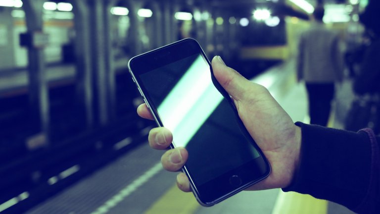 Dateninnovation für smarte Mobilität Hand mit Mobiltelefon am Bahnsteig